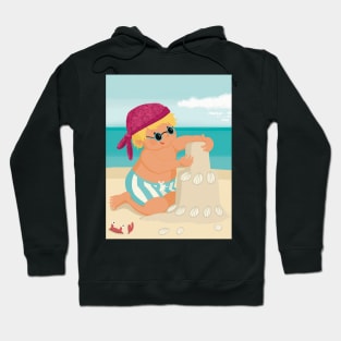 Cute little boy is on vacation building a sand castle on the beach Hoodie